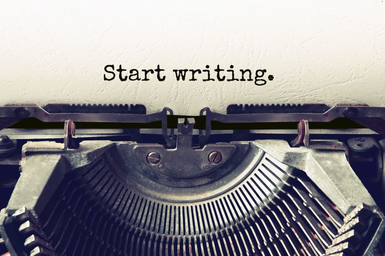 schreibmaschine mit eingelegtem blatt mit aufschrift start writing