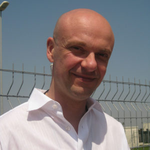Unternehmercoach Joachim Koehrich mit einem weissen Hemd vor einem Zaun