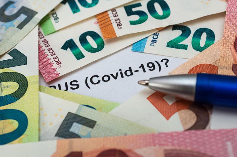 euro geldscheine auf blatt mit schriftzug covid-19 und kugelschreiber