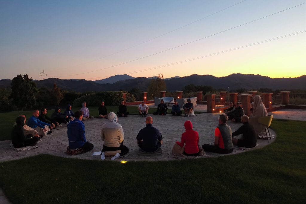 meditieren im schwarzgurt-camp 2021 bei sonnenaufgang und berge im hintergrund