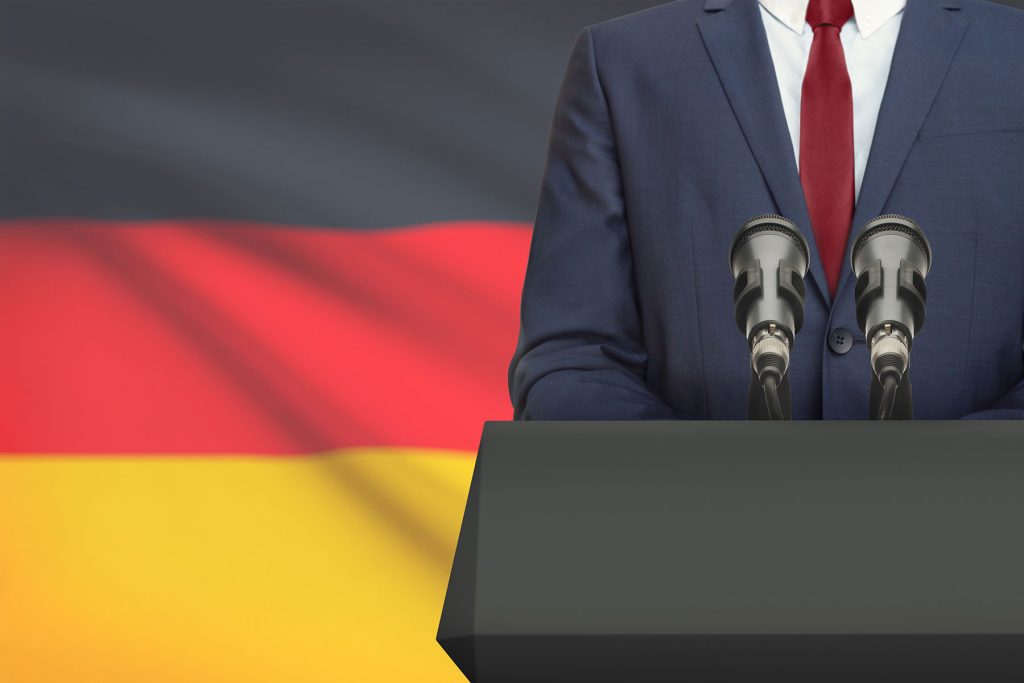 redner-pult mit mikros und deutschland-flagge im hintergrund