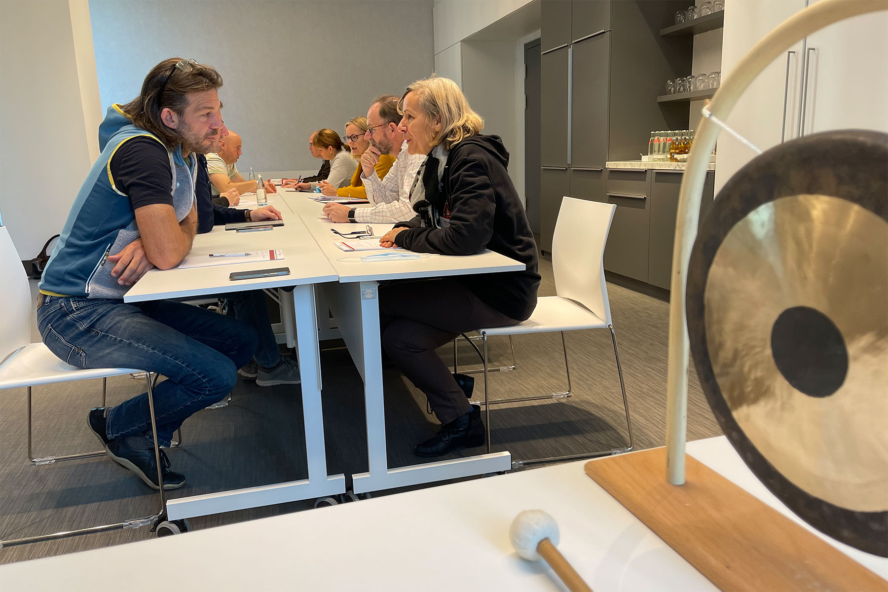 neurostrategie-seminar-teilnehmer am tisch bei speed-coaching mit gong