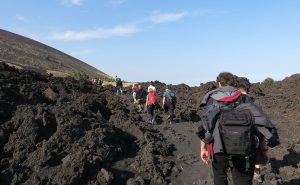 gruppe beim wandern ueber alte vulkan-lawa auf sizilien