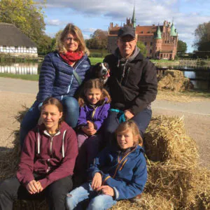 Unternehmercoach Miguel Heise sitzt mit seiner Familie auf Strohballen