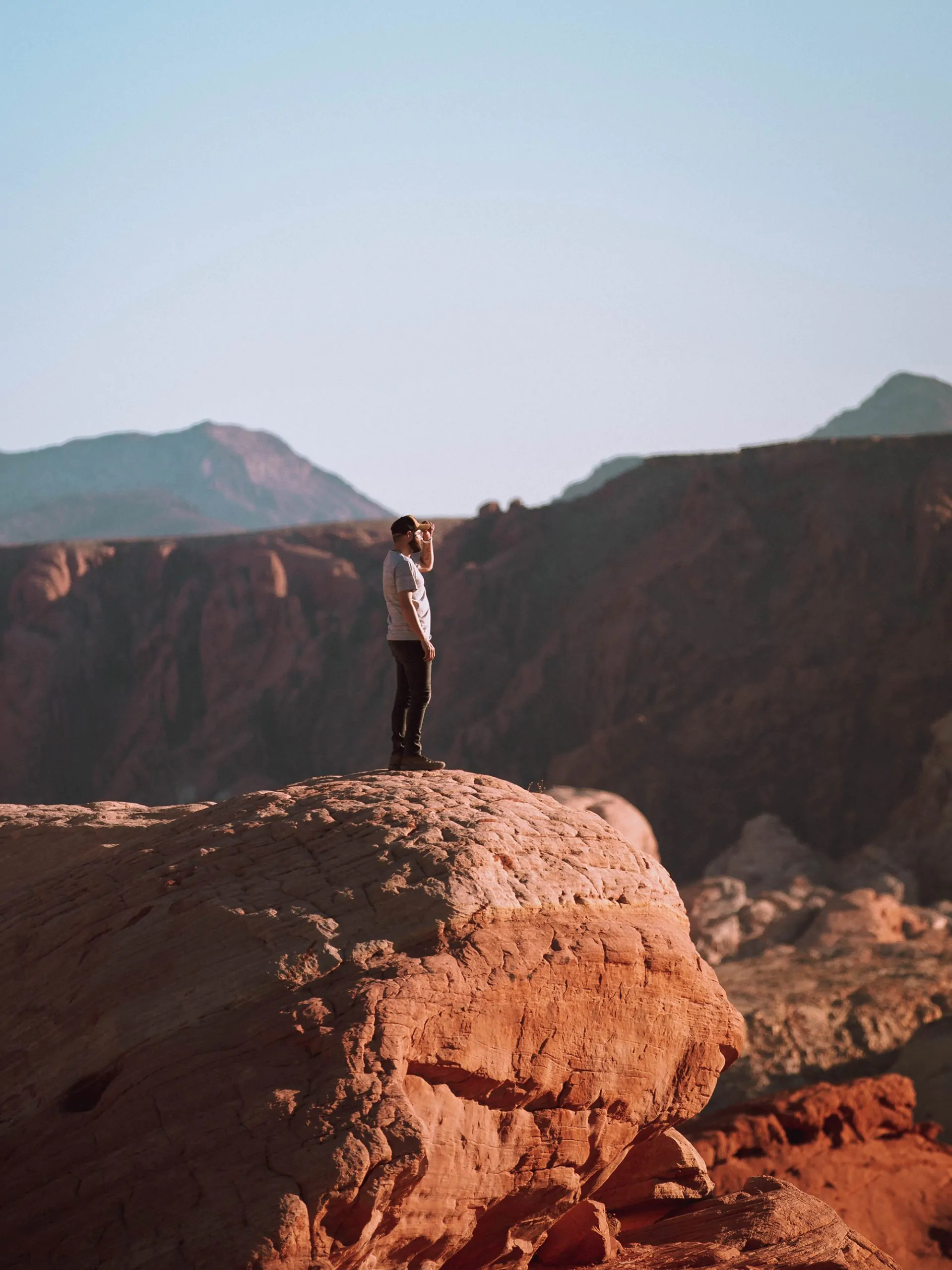 mann steht auf fels und geniesst ausblick ueber grand canyon